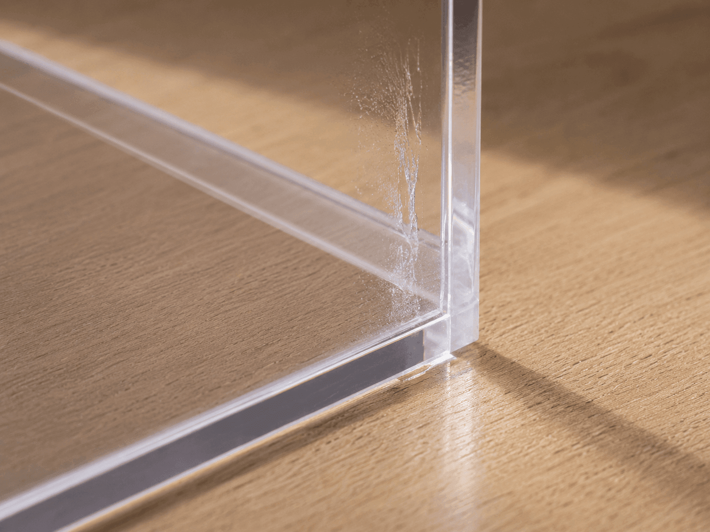 Sichtbare Klebstoffspur auf einer transparenten Acrylglasfläche