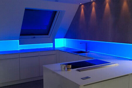 Eine Küchenzeile mit Spitzschutz aus Acrylglas mit blauer Hintergrundbeleuchtung
