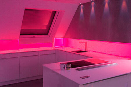 Eine Küchenzeile mit Spitzschutz aus Acrylglas mit roter Hintergrundbeleuchtung