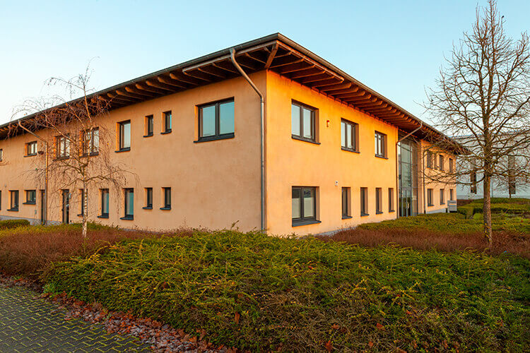 Unser Bürogebäude im goldenen Sonnenaufgang mit Morgenfrost